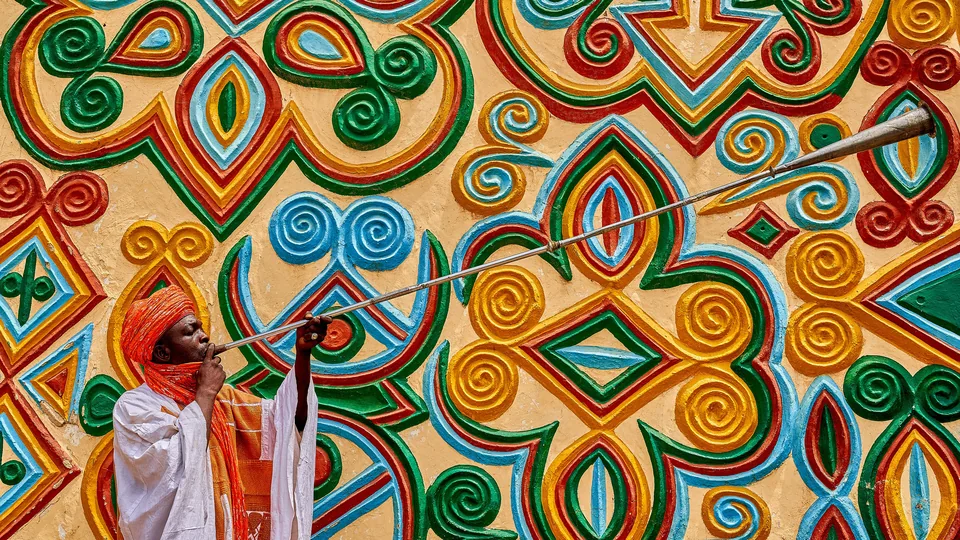 Kakaki trumpeter before the decorated facade of the Zazzau Emir's palace, Zaria